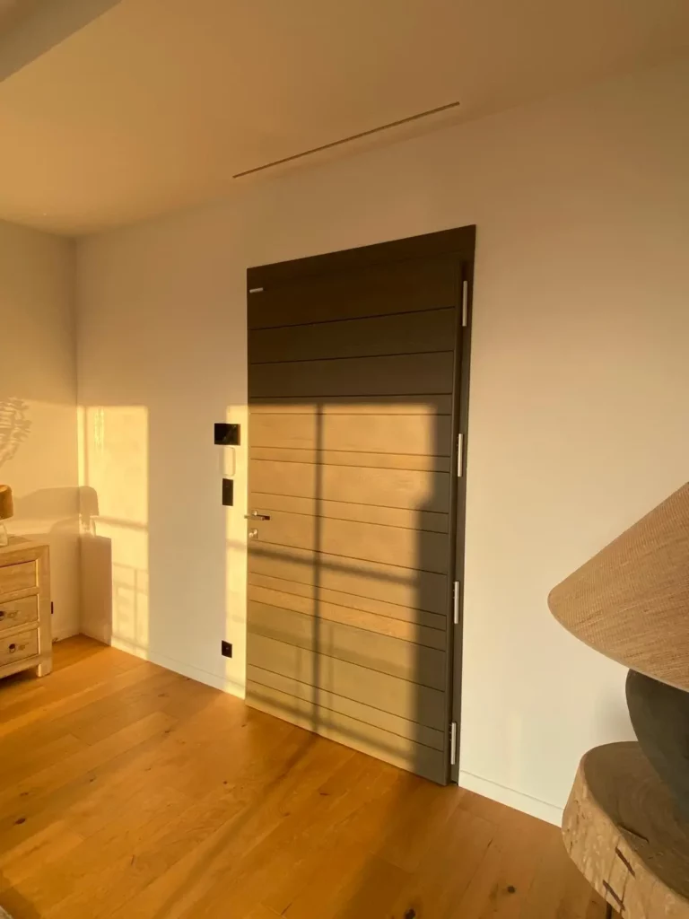 Porte d'entrée en bois sur pivot avec serrure multipoints dans une villa de prestige à Grimaud.